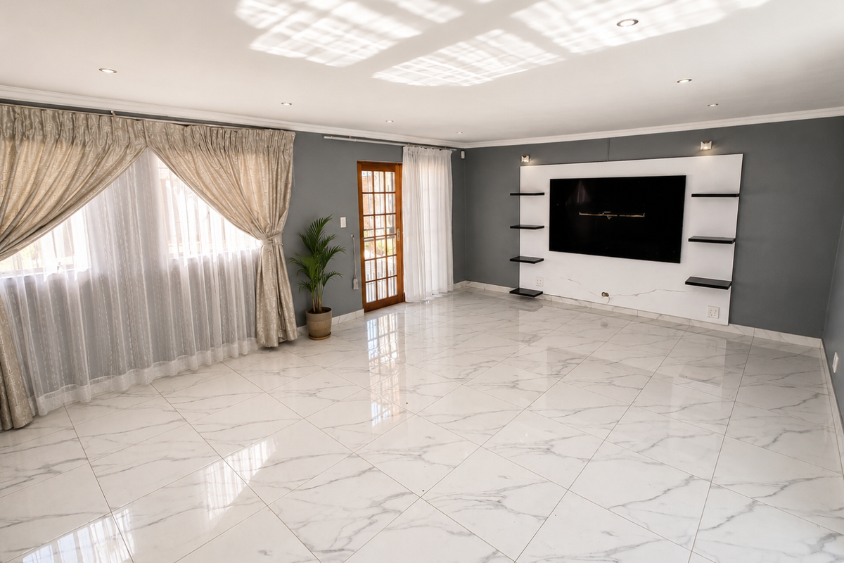 Spacious living room featuring polished marble-look floor tiles, a modern built-in media wall, recessed lighting, and direct access to the exterior via a timber-framed door.