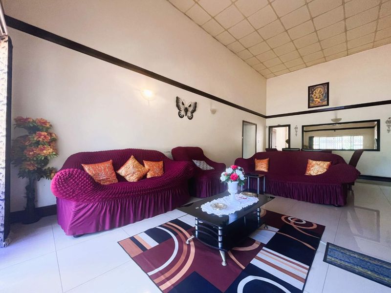Spacious living room featuring high ceilings, tiled flooring, and neutral wall finishes, providing a comfortable area for relaxation and family gatherings.