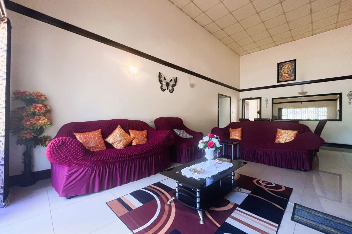 Spacious living room featuring high ceilings, tiled flooring, and neutral wall finishes, providing a comfortable area for relaxation and family gatherings.