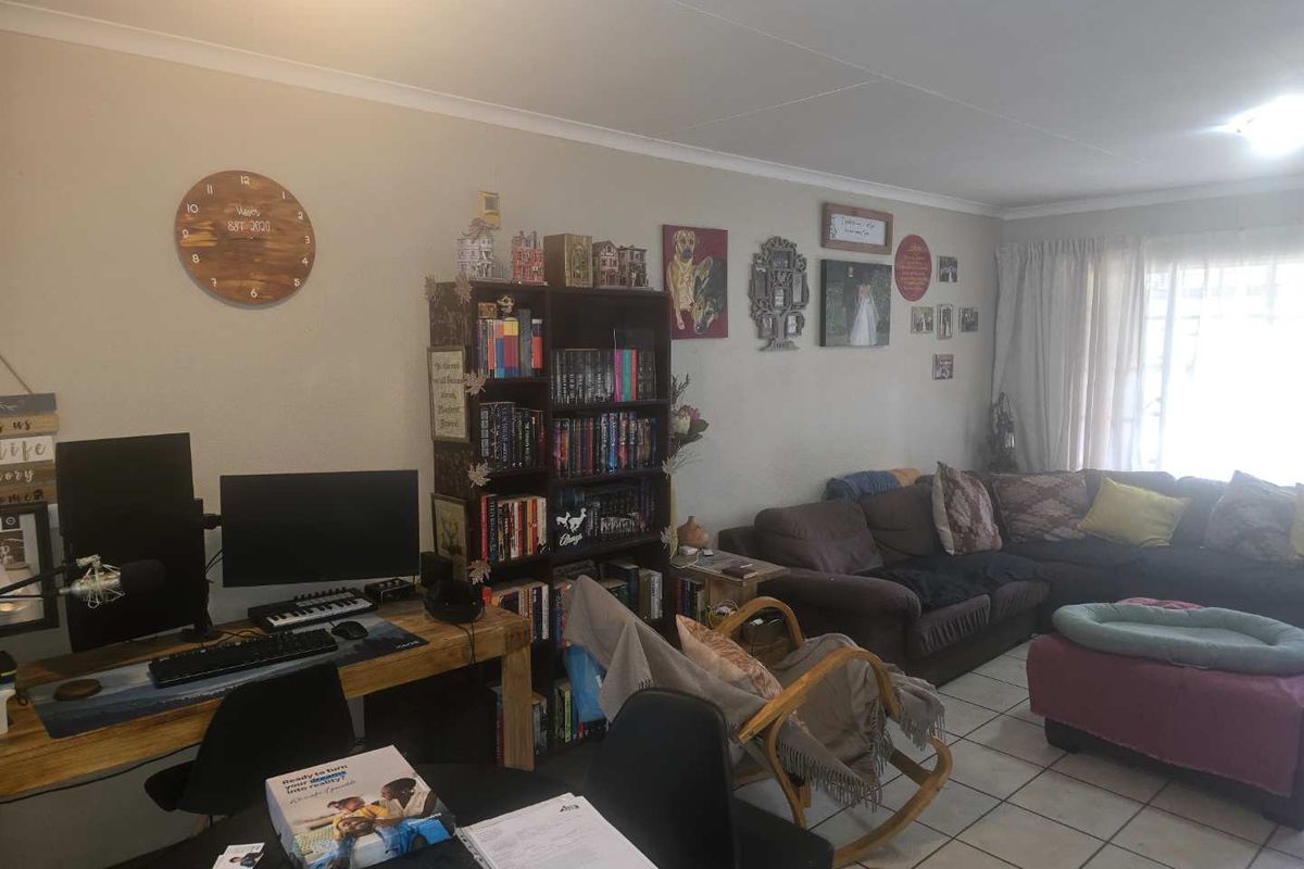 A spacious living area featuring tiled flooring and coved ceilings, offering a versatile layout for relaxation and home office use.
