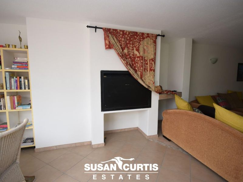 Living room area featuring a built-in fireplace and tiled flooring.