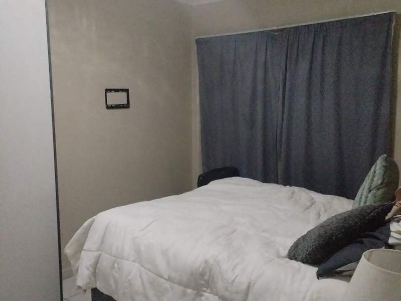 A functional bedroom featuring tiled flooring and a built-in wardrobe, providing a neutral base for personalization.