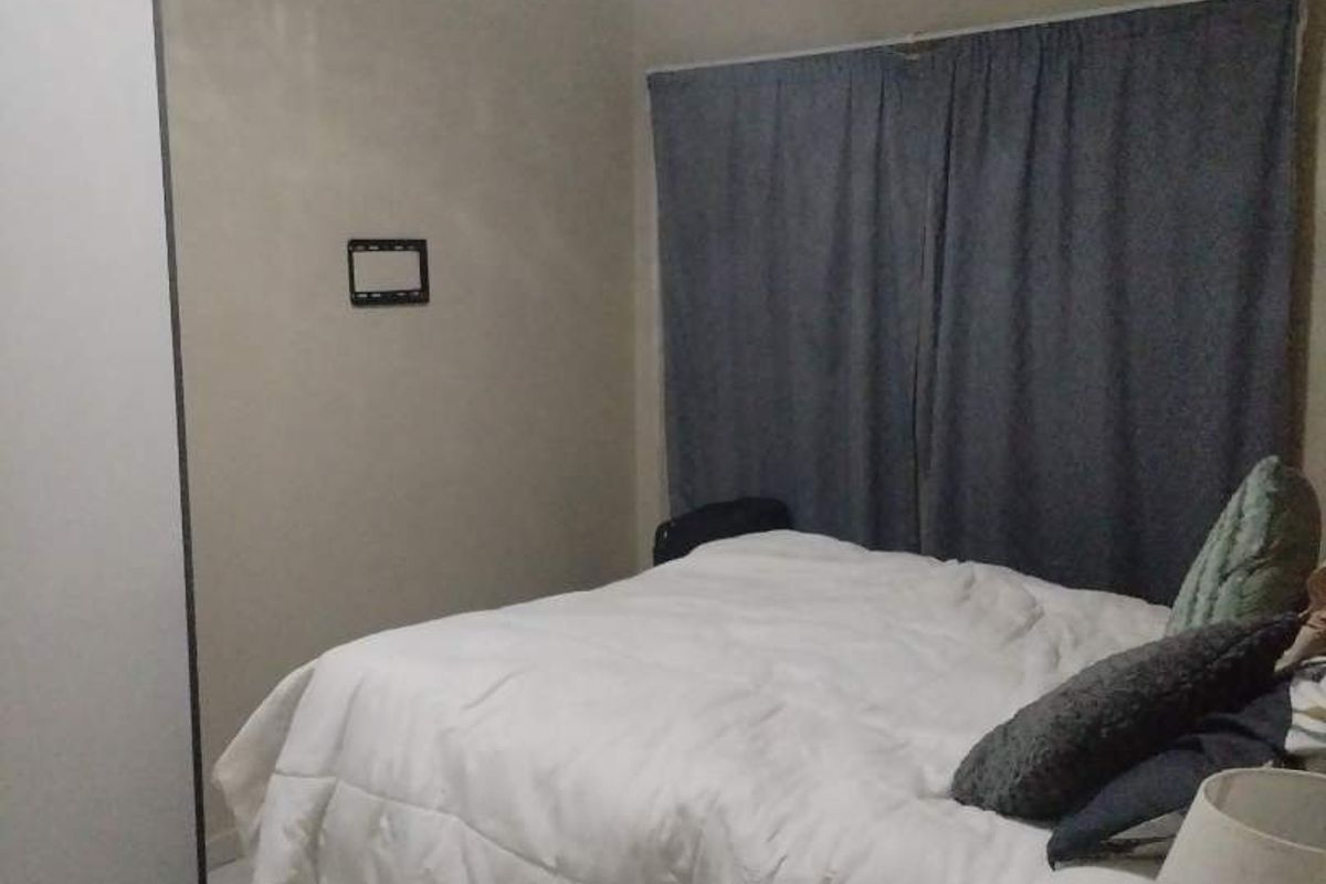 A functional bedroom featuring tiled flooring and a built-in wardrobe, providing a neutral base for personalization.