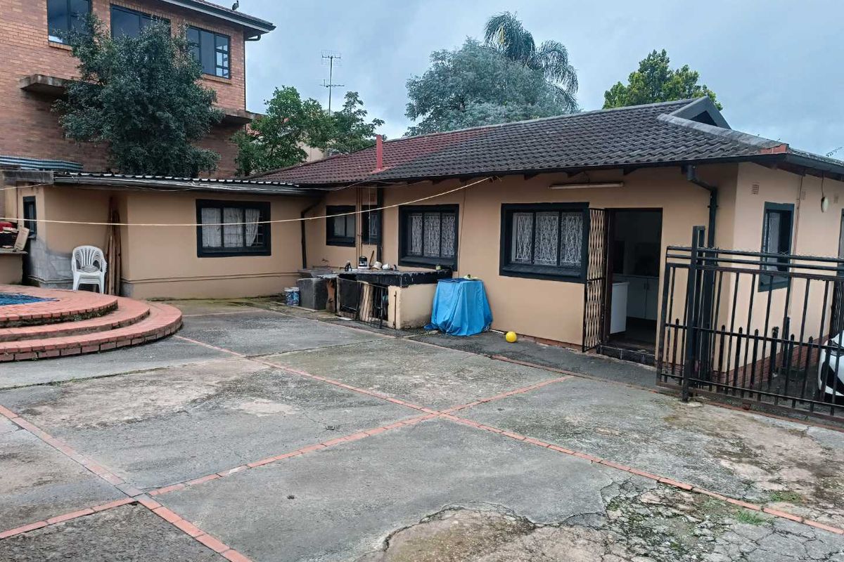 Rear exterior view of the property featuring a concrete patio area, swimming pool, and direct access to the main dwelling.