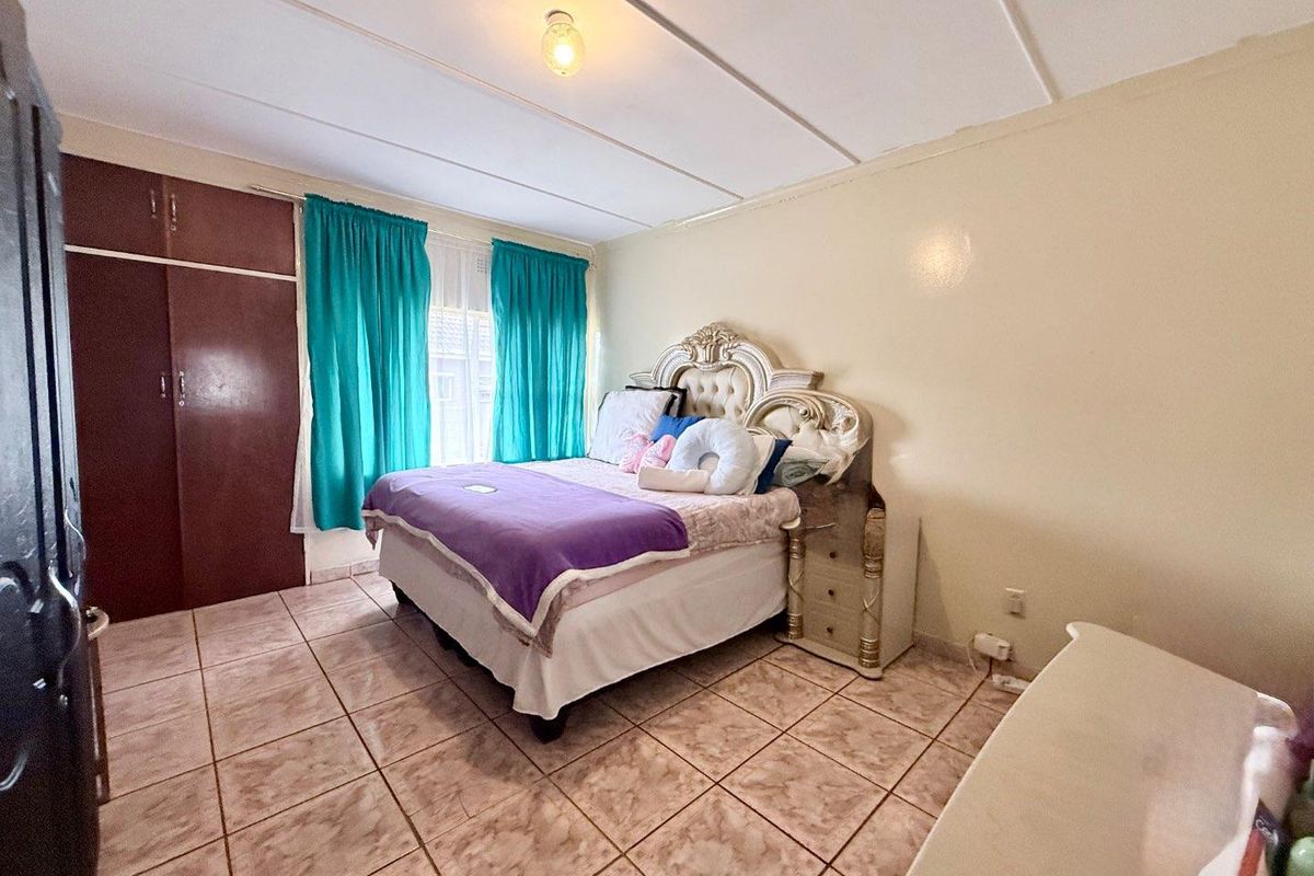 A bedroom featuring built-in cupboards, tiled flooring, and a standard ceiling finish.