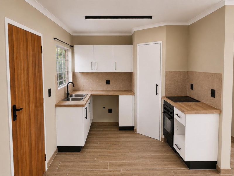 A modern, clean kitchen featuring white cabinetry, wood-look laminate countertops, a built-in oven with hob, and tiled flooring in a neutral color palette.