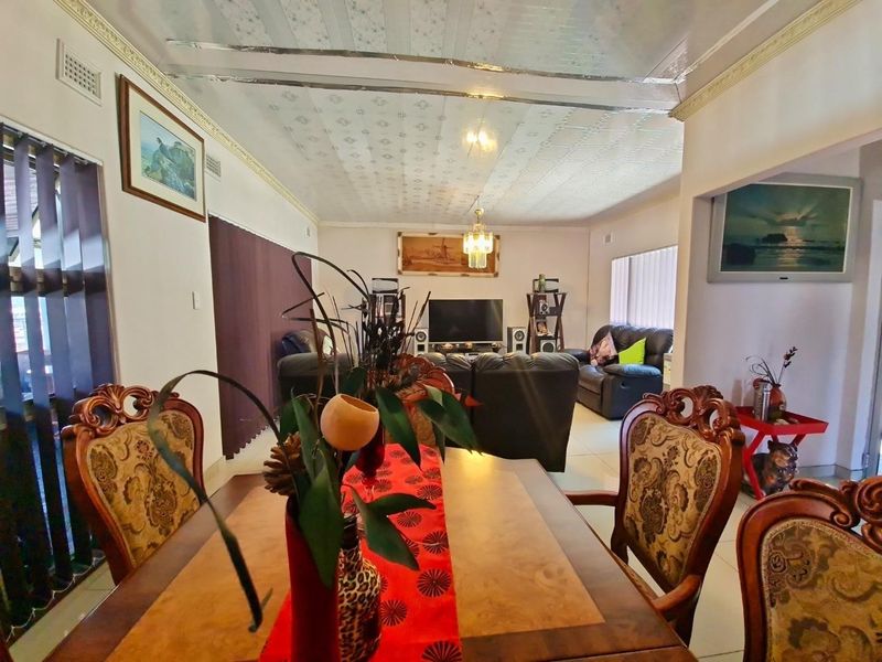 Open plan living and dining area featuring tiled flooring and decorative ceiling tiles, providing a functional space for family living.