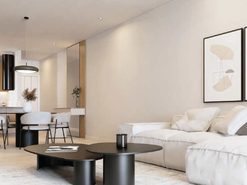 Modern open-plan living and kitchen area featuring neutral tones, recessed lighting, and sleek contemporary cabinetry with a minimalist aesthetic.