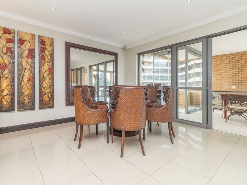 Bright dining room featuring polished porcelain floor tiles, recessed lighting, and large sliding glass doors providing seamless access to the outdoor patio area.