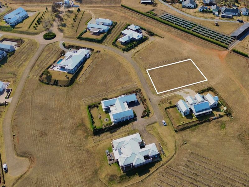 Aerial view of a vacant residential plot situated within a developed estate, featuring clear boundaries and access to established infrastructure.