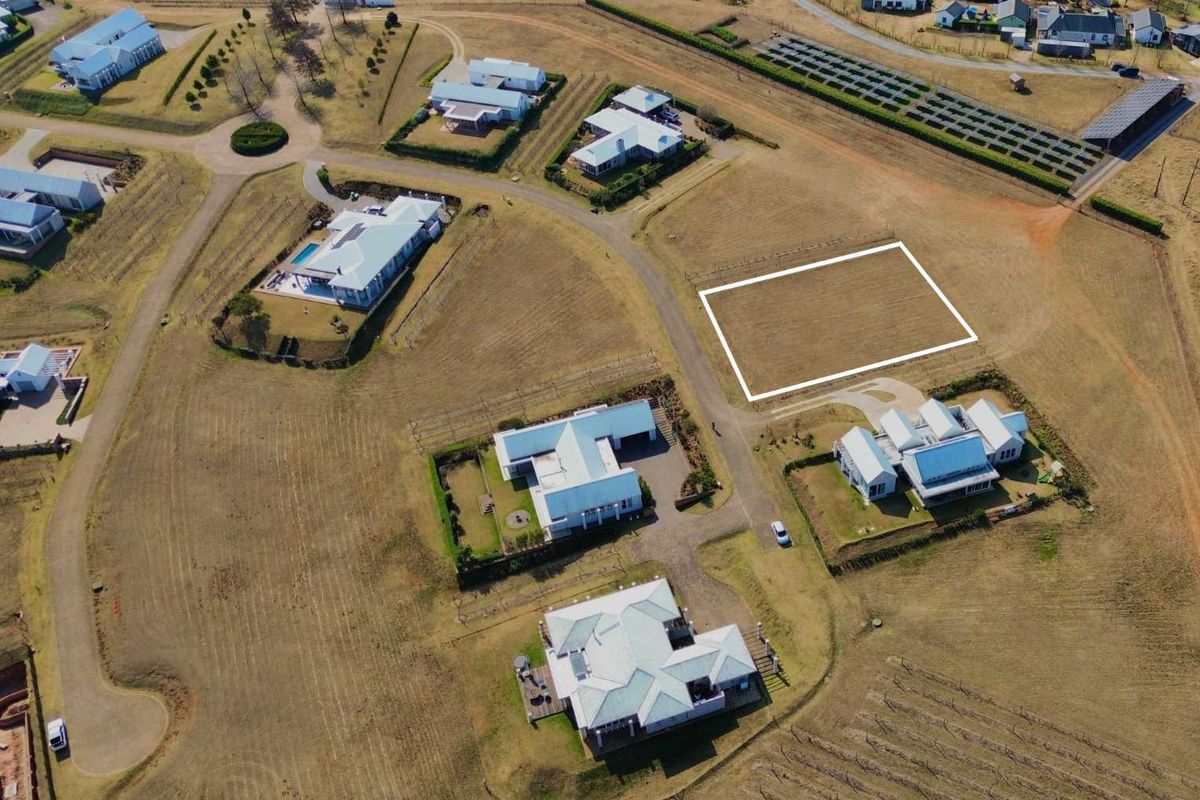 Aerial view of a vacant residential plot situated within a developed estate, featuring clear boundaries and access to established infrastructure.