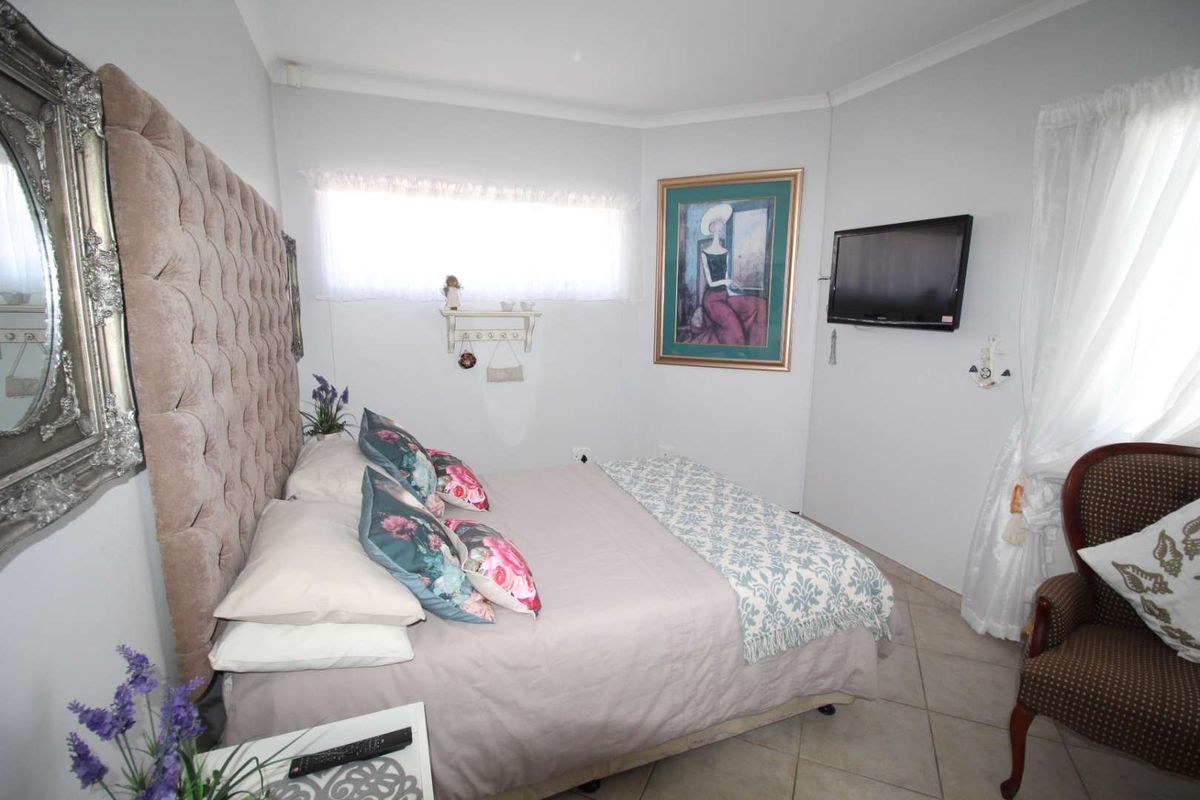 A bedroom featuring tiled flooring and coved ceiling details, providing a functional space with neutral wall finishes.