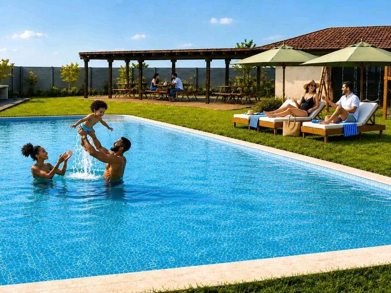 A well-maintained outdoor pool area featuring a tiled swimming pool, a timber pergola for shade, and landscaped lawn space.