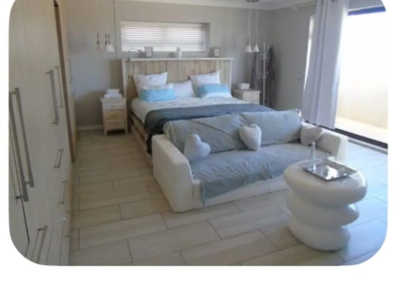 Spacious master suite featuring tiled flooring, extensive built-in cabinetry, and direct access to a private balcony through sliding glass doors.