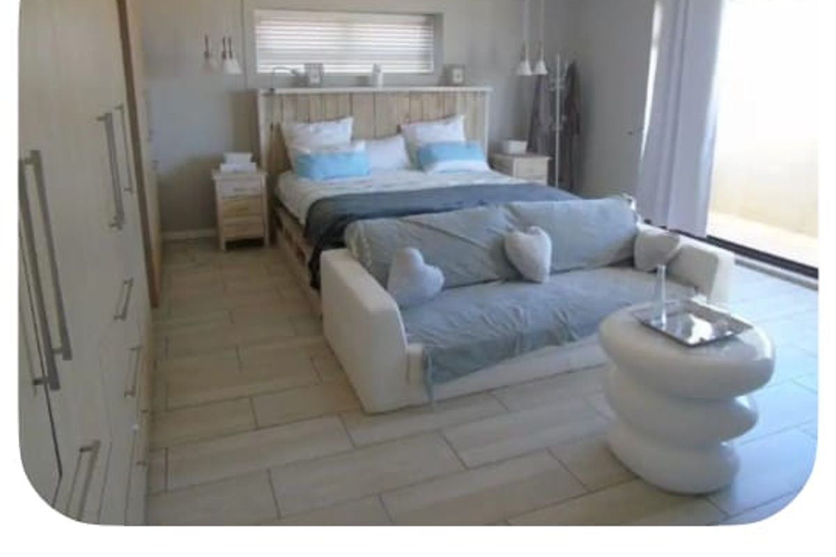 Spacious master suite featuring tiled flooring, extensive built-in cabinetry, and direct access to a private balcony through sliding glass doors.