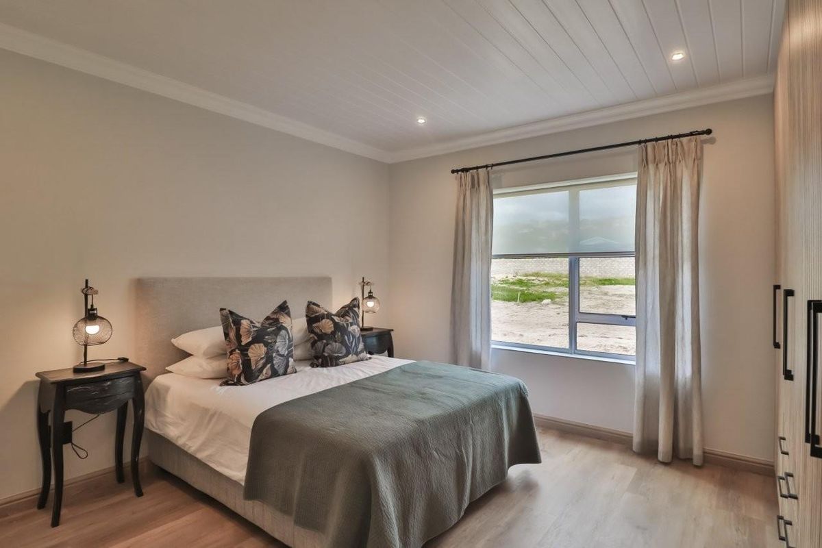 A well-maintained bedroom featuring light wood-look flooring, recessed ceiling lighting, and built-in cabinetry.