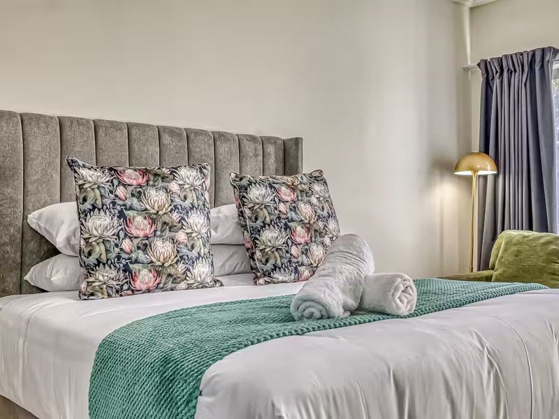 A well-maintained bedroom featuring neutral wall finishes and window treatments, providing a comfortable and inviting sleeping space.