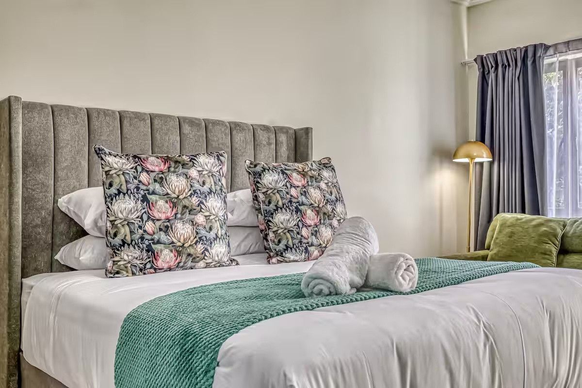 A well-maintained bedroom featuring neutral wall finishes and window treatments, providing a comfortable and inviting sleeping space.