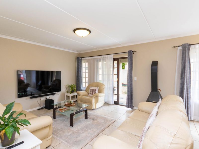 A comfortable living room featuring tiled flooring, a freestanding fireplace, and a sliding glass door providing access to the outdoor area.