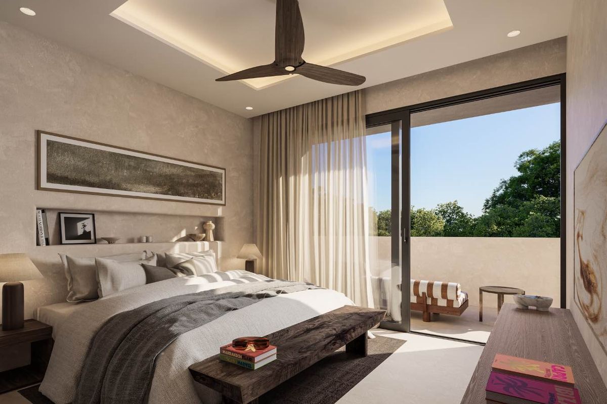 A modern, well-appointed bedroom featuring a recessed ceiling with integrated lighting, a ceiling fan, and large sliding glass doors opening to a private balcony.