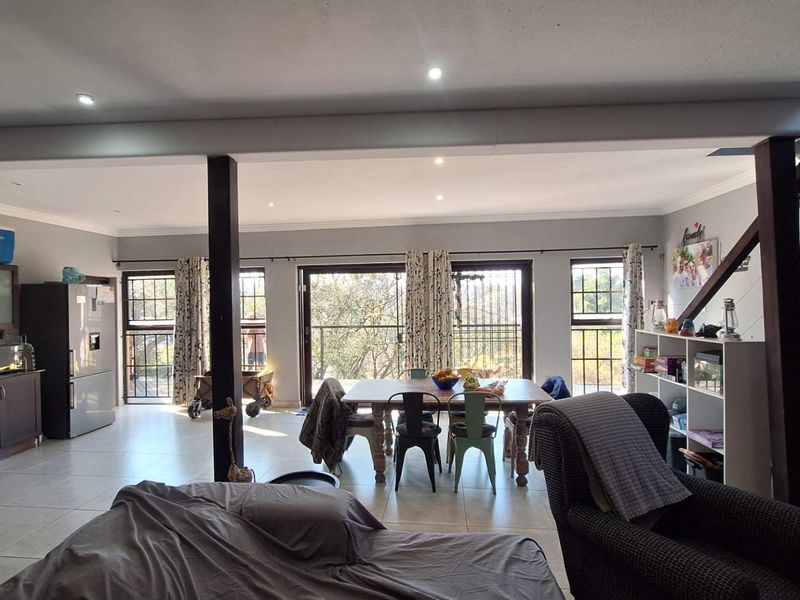 Spacious open-plan living and dining area featuring tiled floors, recessed lighting, and direct access to an outdoor balcony through sliding glass doors.