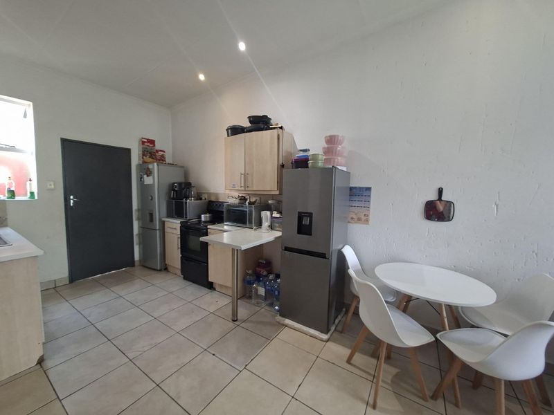 A functional kitchen area featuring tiled flooring, built-in cabinetry, and a stove, offering a practical layout for daily meal preparation.