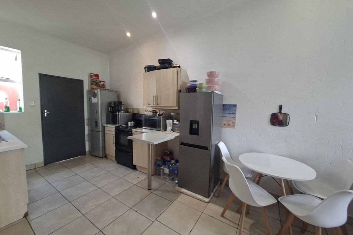 A functional kitchen area featuring tiled flooring, built-in cabinetry, and a stove, offering a practical layout for daily meal preparation.