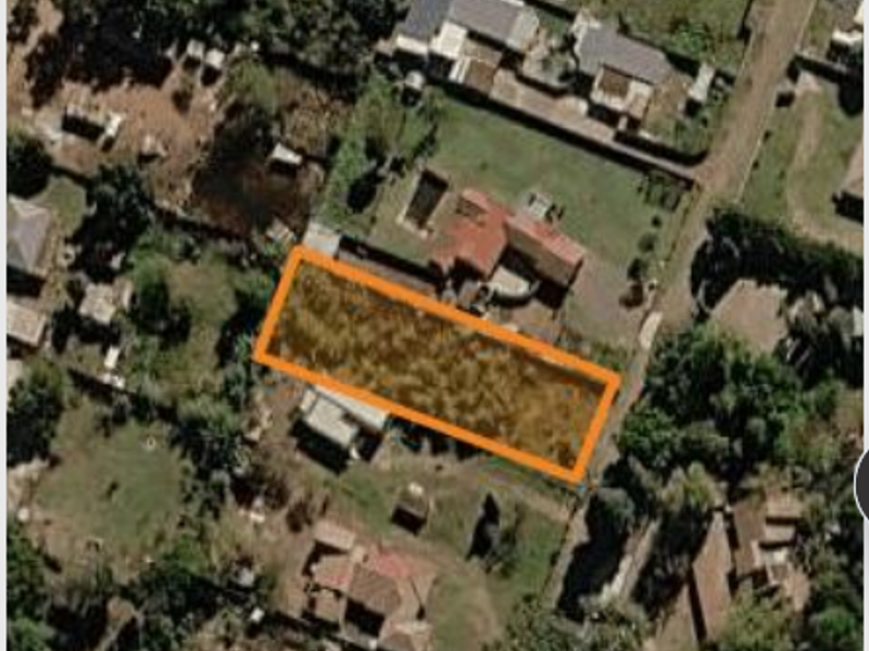 An aerial view of a vacant residential land parcel highlighted in orange, situated within an established suburban neighborhood.