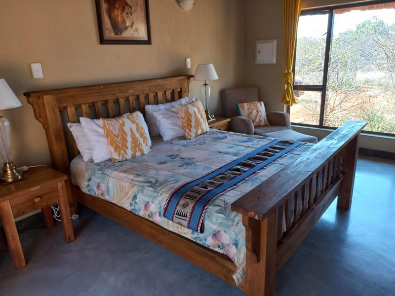A well-maintained bedroom featuring polished concrete flooring, large windows with natural light, and neutral wall finishes.