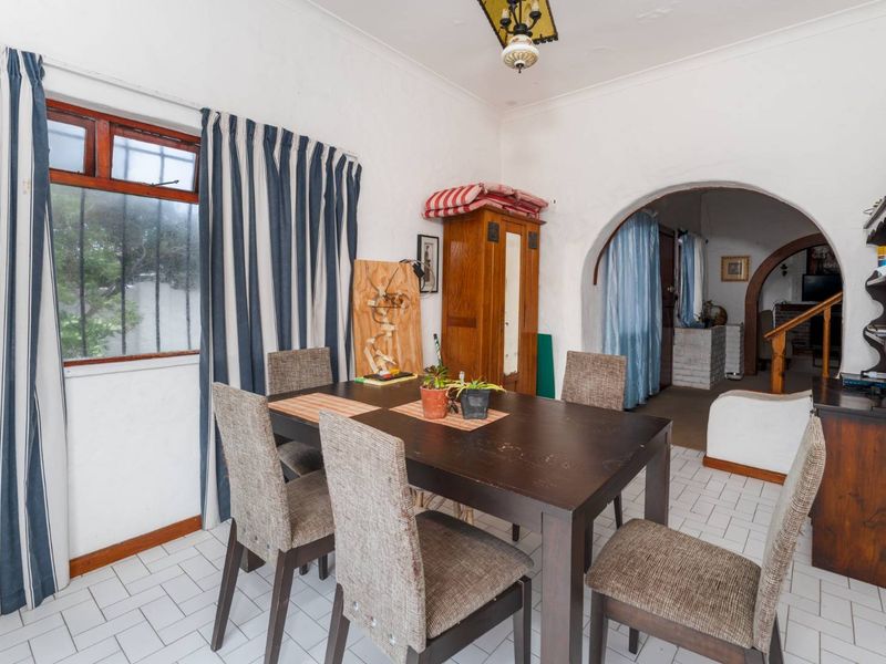 Dining area featuring tiled flooring and a distinctive arched doorway leading to adjacent living spaces.