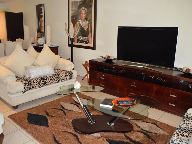 A comfortable living room area featuring tiled flooring and a neutral wall palette, providing a functional space for relaxation.