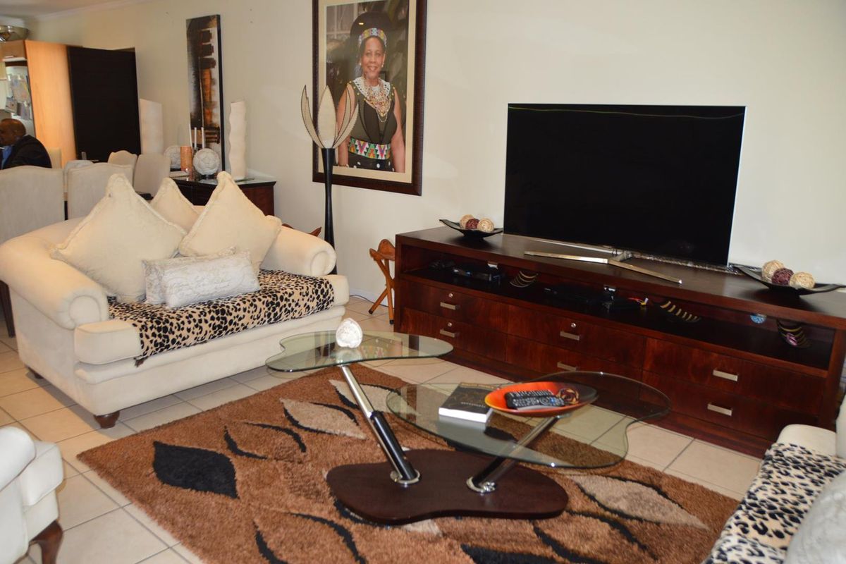 A comfortable living room area featuring tiled flooring and a neutral wall palette, providing a functional space for relaxation.