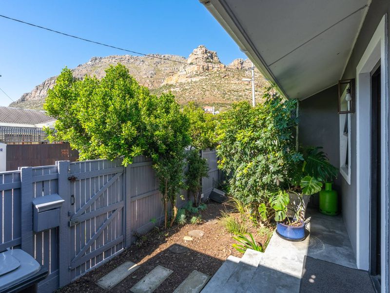 A private rear courtyard area featuring a concrete patio, timber fencing, and mountain views.