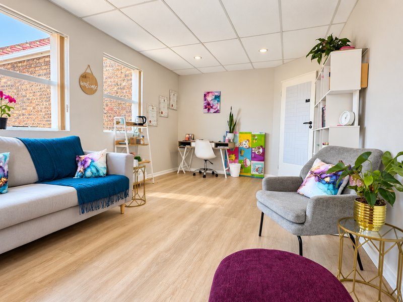 A bright and well-maintained office space featuring modern laminate flooring, a suspended ceiling with recessed lighting, and large windows providing natural light.
