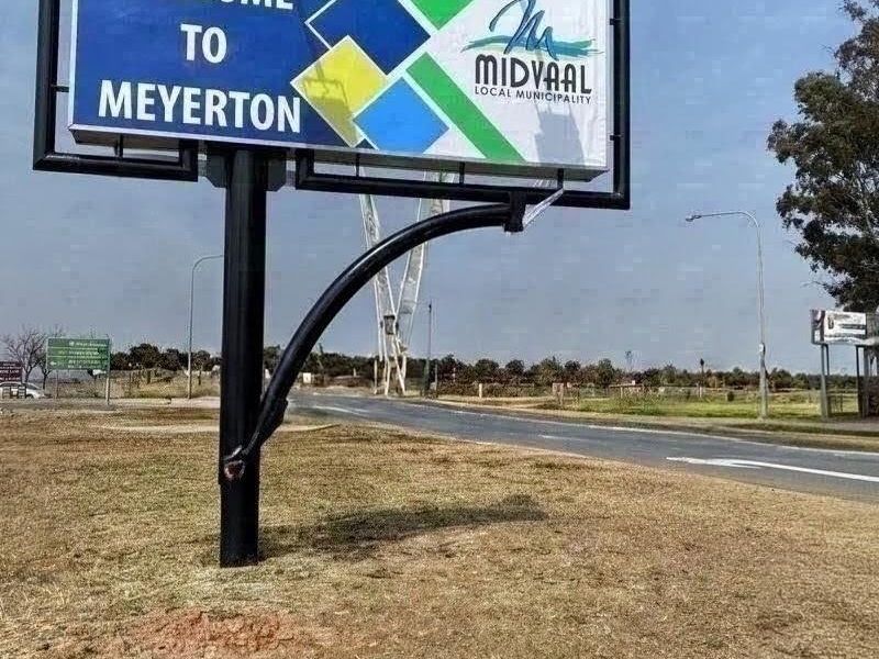 A roadside welcome sign for the Meyerton area, featuring a large municipal billboard structure situated along a paved road.