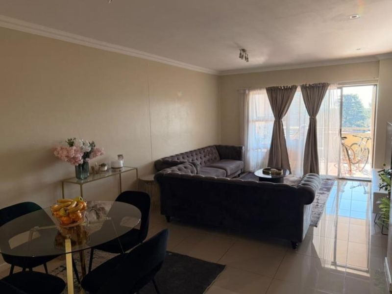 Open-plan living and dining area featuring tiled flooring and a sliding glass door providing access to a balcony.