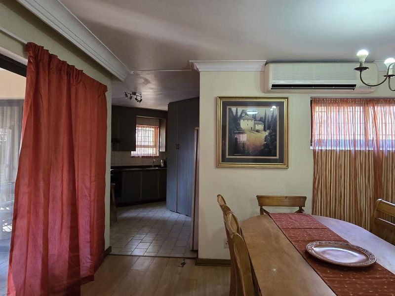 Open plan dining area featuring tiled and laminate flooring, split-system air conditioning, and direct access to an outdoor patio space.