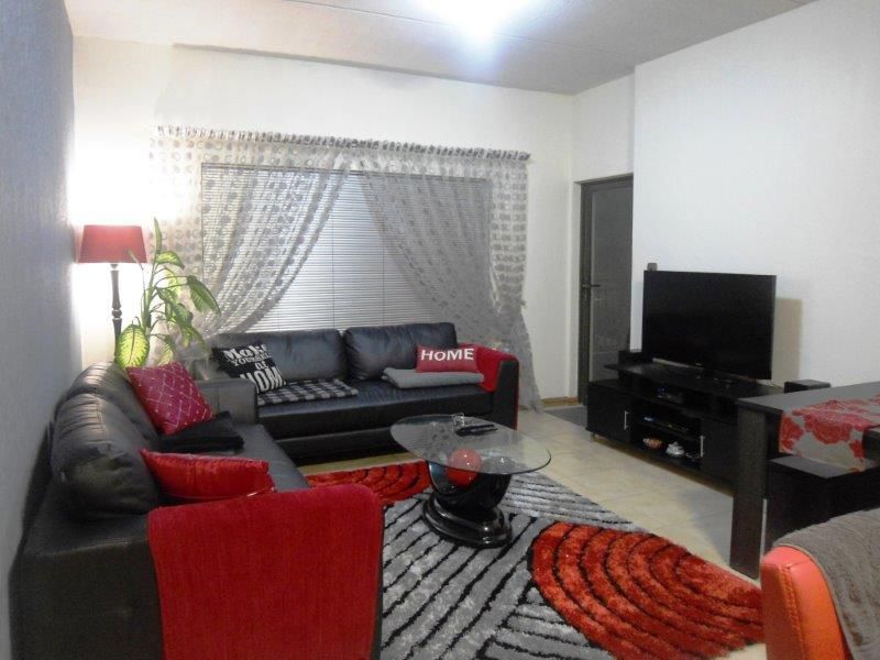 A living room featuring tiled flooring and venetian blinds, providing a functional space for relaxation and entertainment.