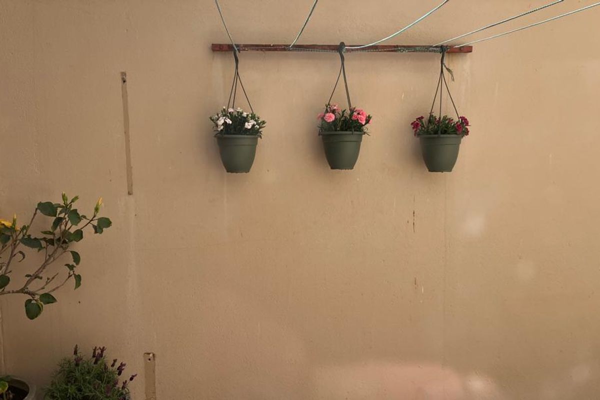 A rear exterior wall area featuring a mounted clothesline, showing signs of wear and surface staining on the painted finish.
