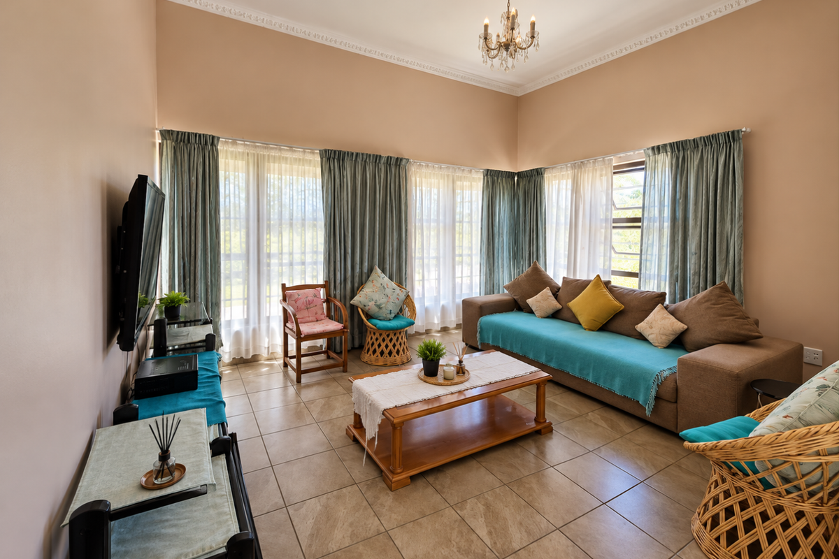 Spacious living room featuring tiled flooring, decorative ceiling cornice, a classic chandelier, and large windows allowing for ample natural light.