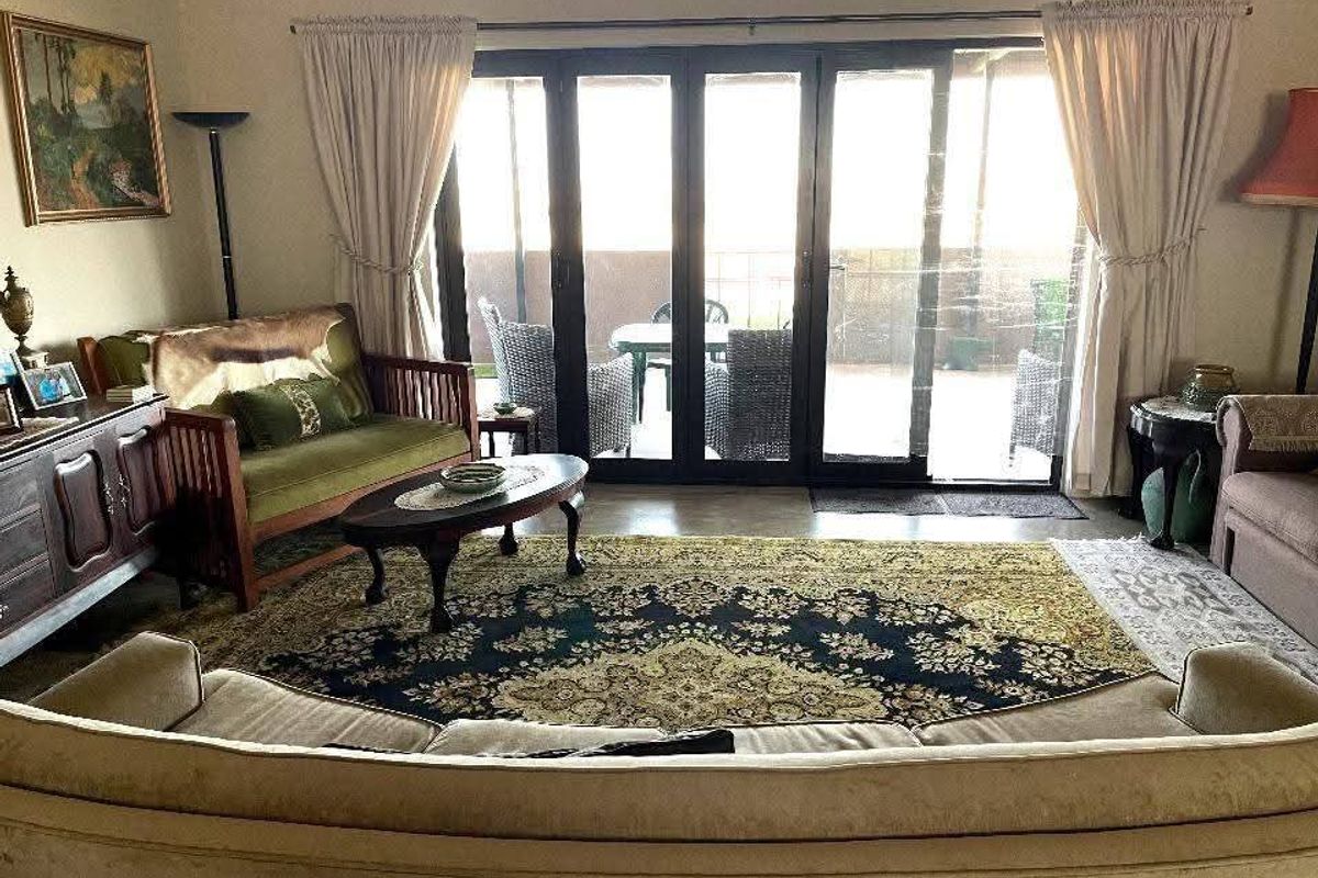 A comfortable living room featuring large black-framed sliding glass doors that provide direct access to an outdoor patio area.