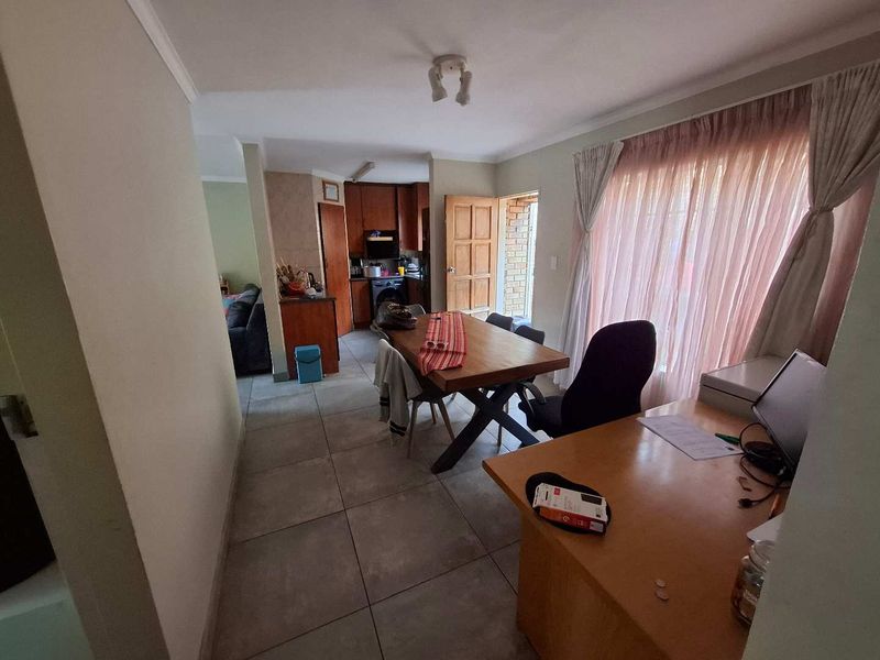 Open plan living and dining area featuring tiled flooring and direct access to the kitchen and exterior.