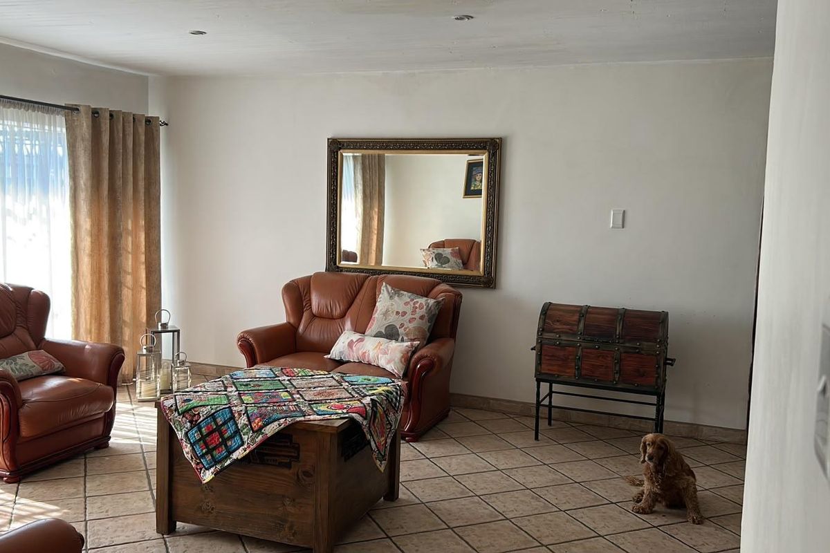 A living room featuring tiled flooring and recessed downlights, providing a neutral base for interior design updates.