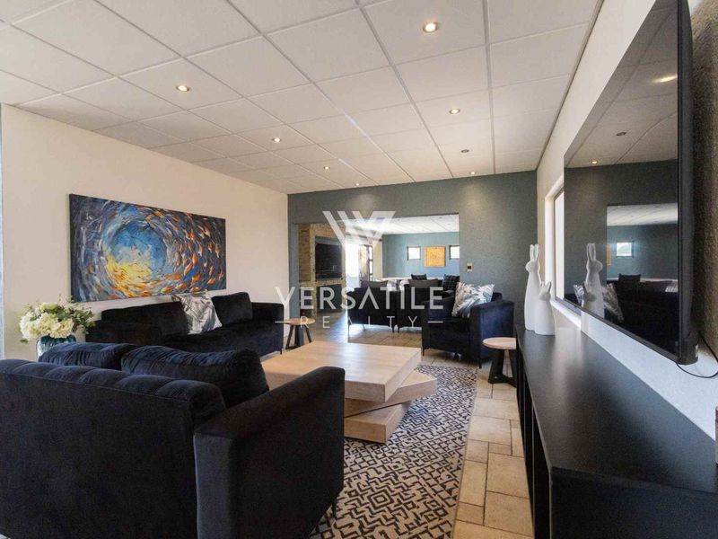 Spacious living room featuring tiled flooring, recessed downlighting, and a suspended ceiling, offering a comfortable and functional layout for relaxation.