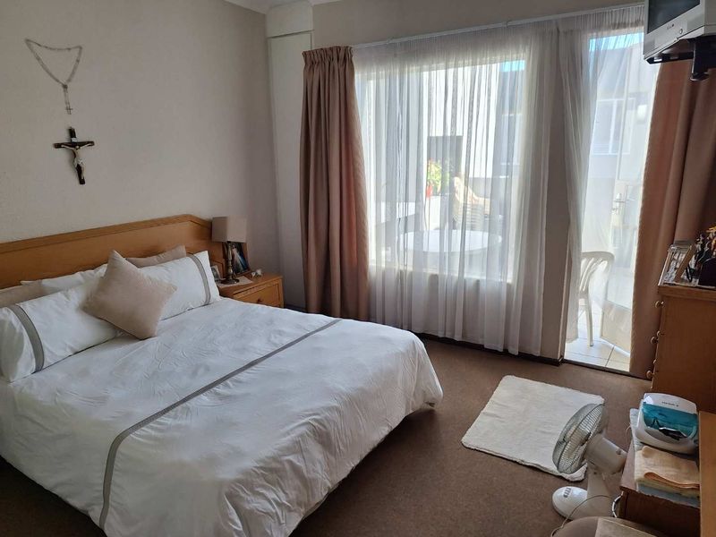A bedroom featuring carpet flooring and a sliding glass door providing access to an outdoor patio area.