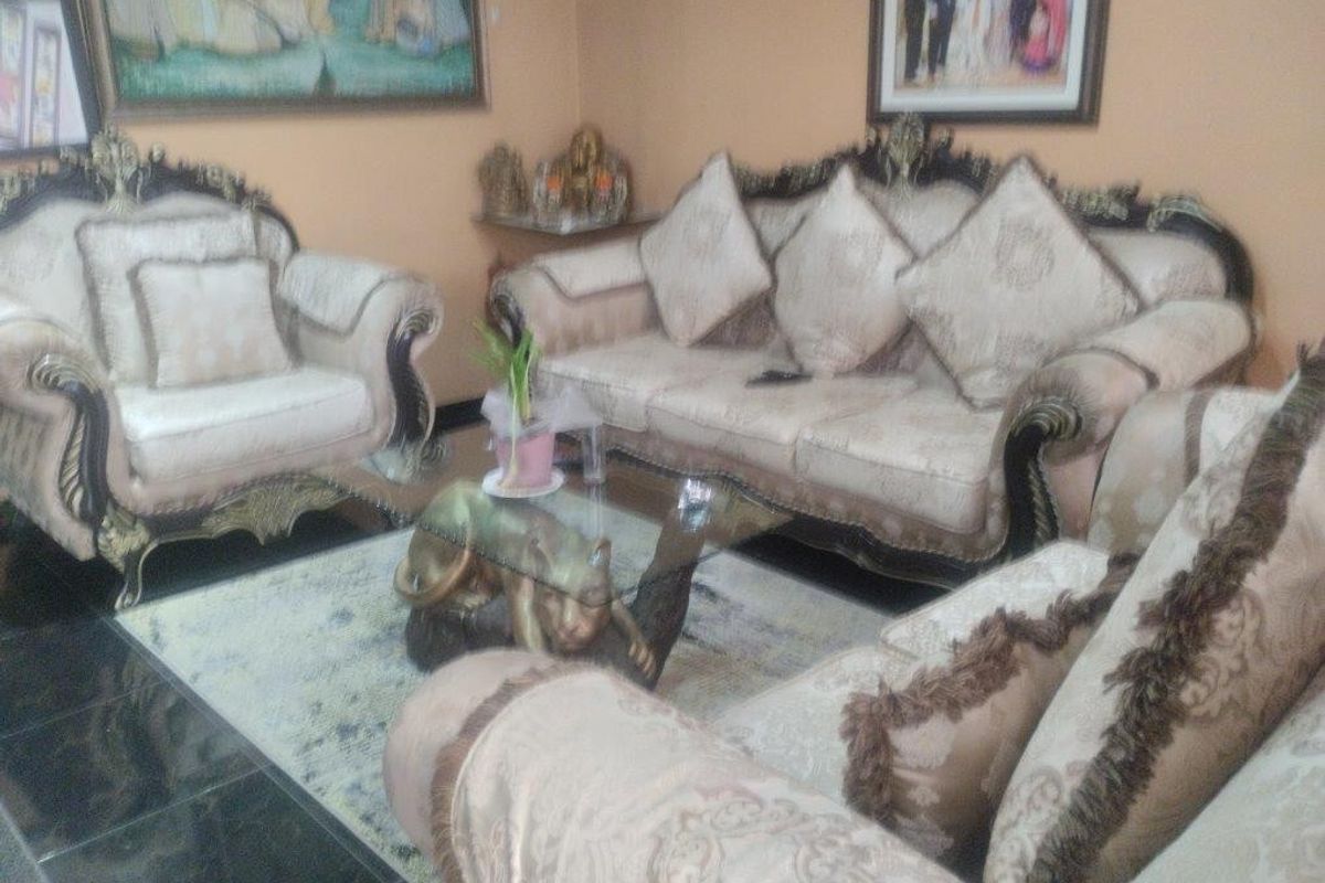 A living room area featuring dark tiled flooring and neutral wall finishes.