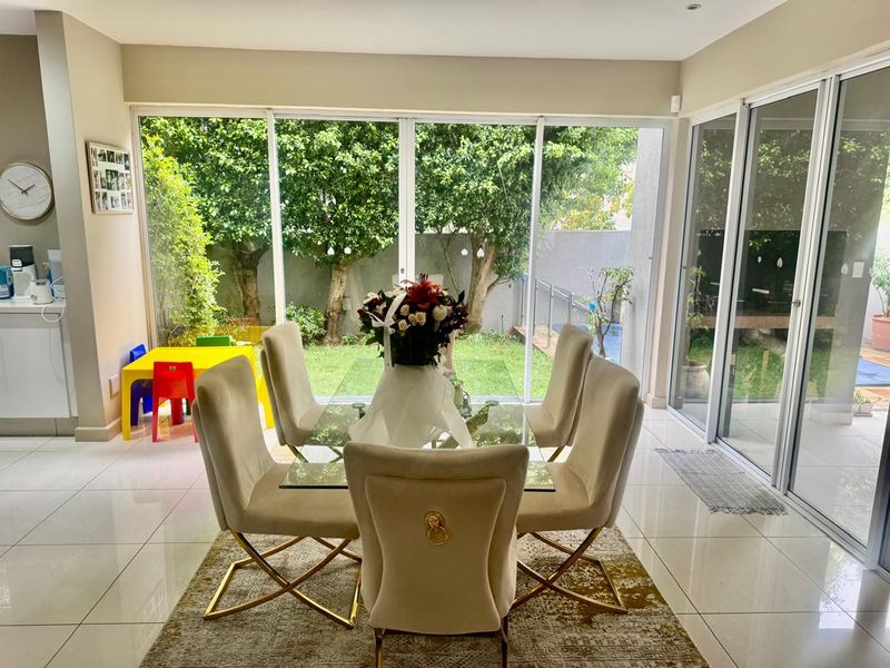 Bright dining area featuring large sliding glass doors that provide seamless access to the garden and allow for abundant natural light.