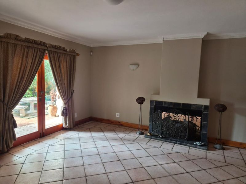 Spacious living room featuring tiled flooring, a built-in fireplace with a tiled surround, and sliding glass doors providing access to the outdoor patio area.