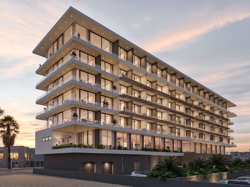 A modern multi-story apartment building featuring extensive glass facades, private balconies, and contemporary architectural design.
