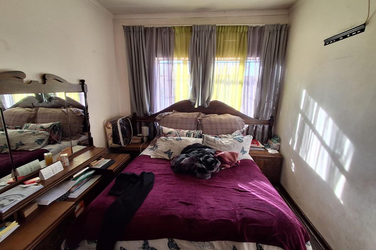 A standard bedroom featuring a window with curtain rails, providing natural light and a functional layout for a sleeping space.